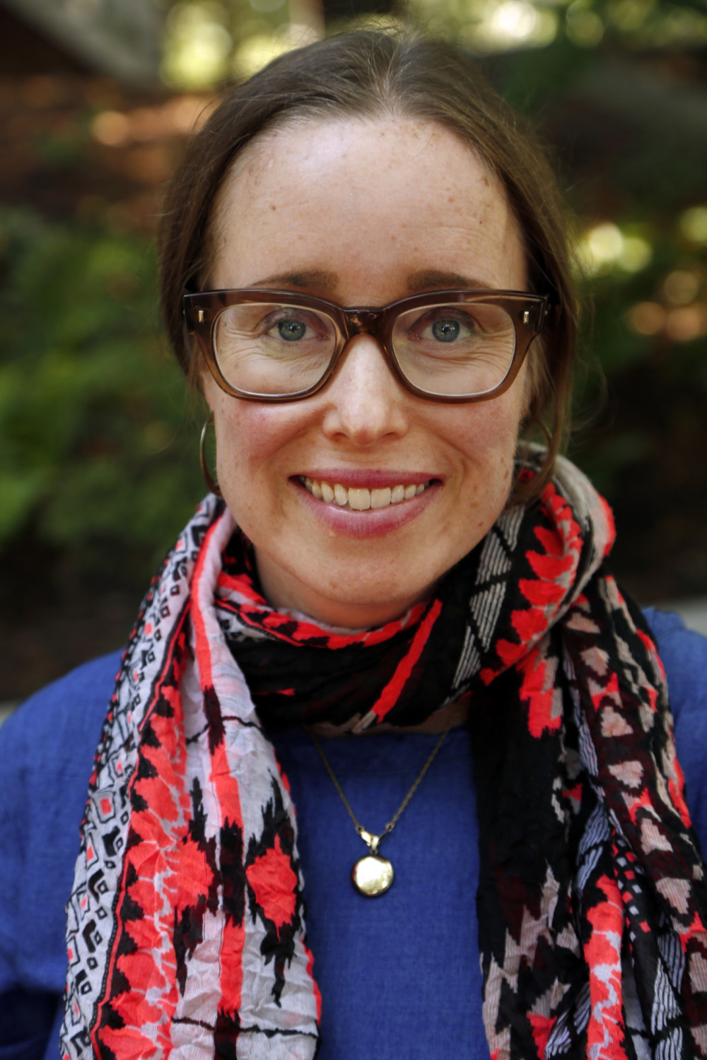 Katherine Charles in glasses and a blue sweater