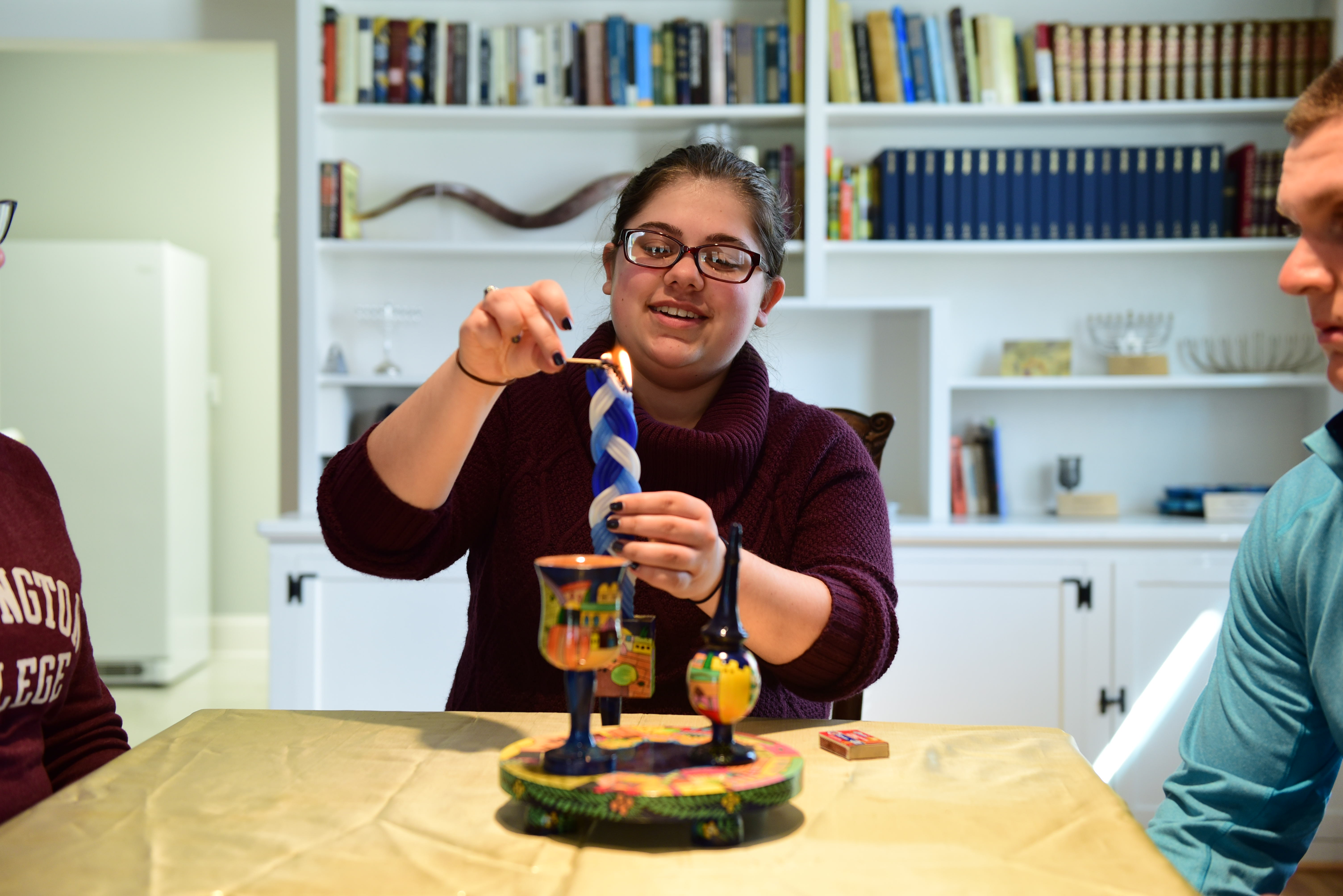 WC Hillel Student lights a candle 