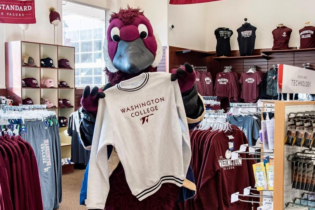 Gus the Goose Mascot holding a Washington College Sweatshirt