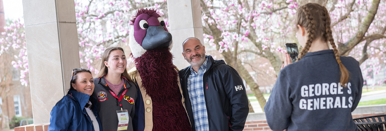 a family gets their picture taken with Gus the Goose mascot