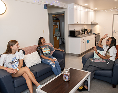 Students talking in the common area of a Western Shore suite.