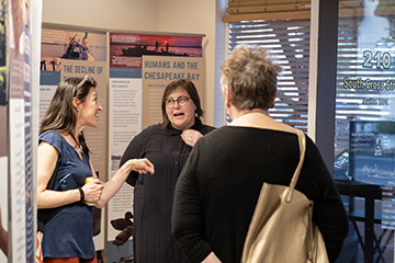 Three people talk in an exhibit at MuSE.