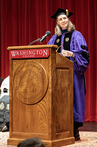 Professor Emily Steinmetz behind the lectern in her academic regalia