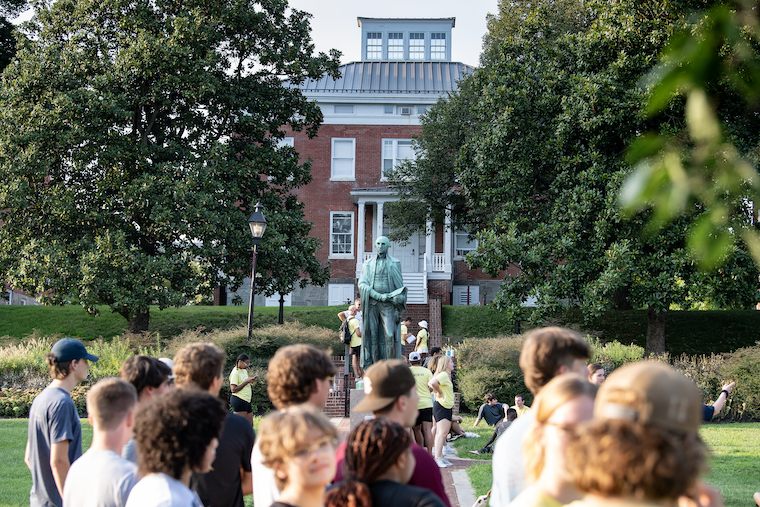 Washington College students pass in front of a statue of George Washington on the Campus Green. 