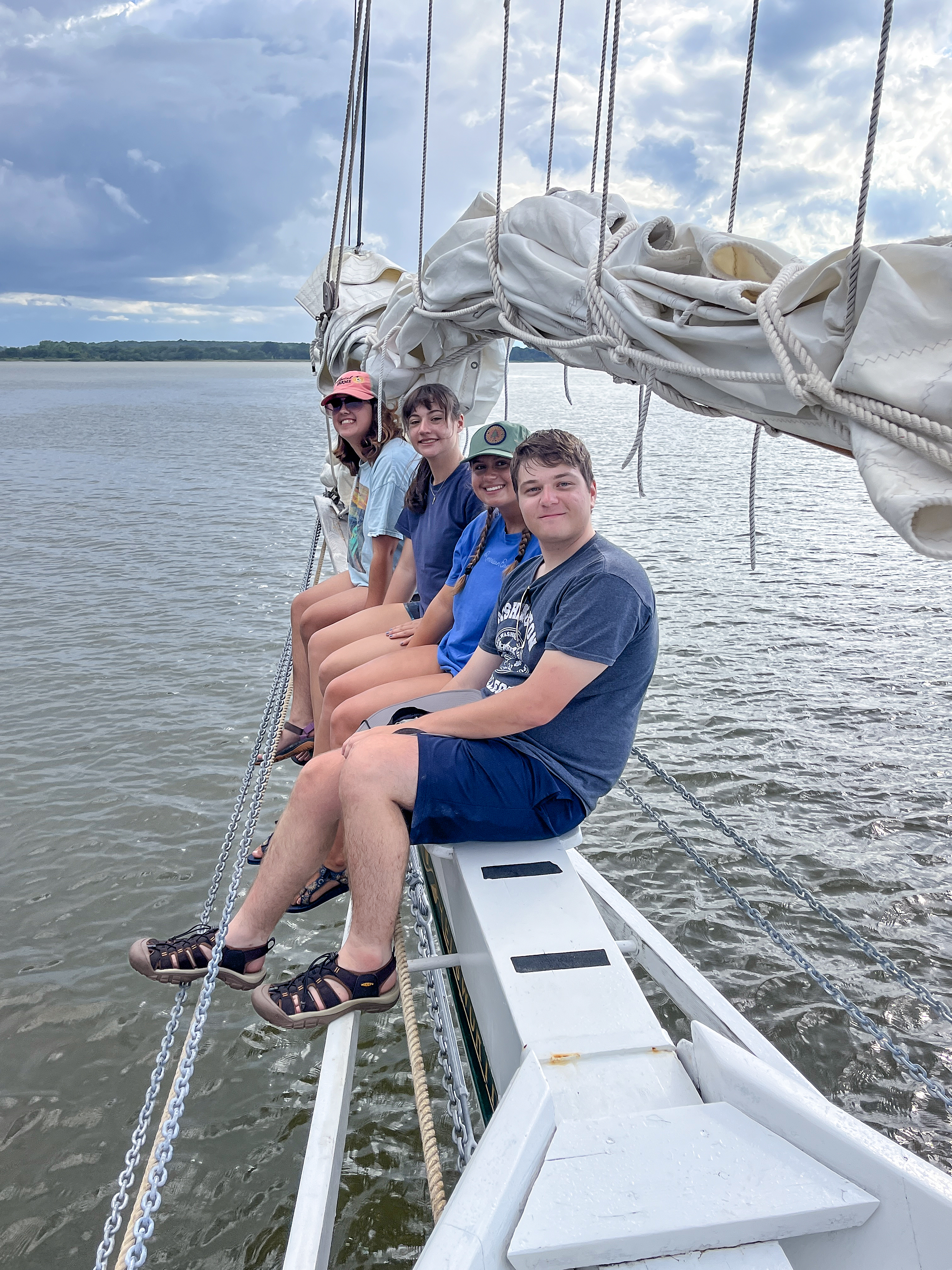 students sitting on sailboat