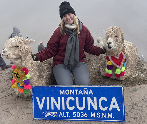 Rachel Beall '25 with two llamas on a mountaintop in Peru